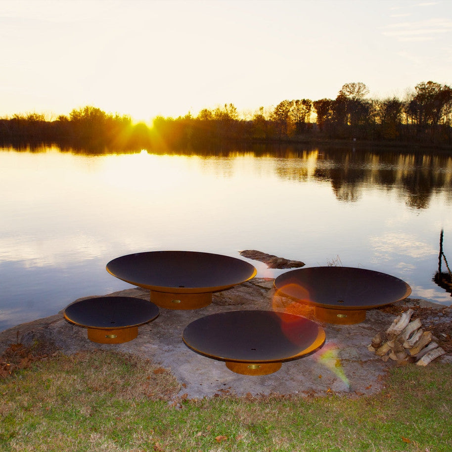 Fire pit area by a lake with sunset reflection