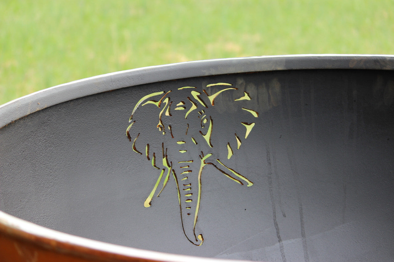 Decorative metal bowl with a floral cutout on a grassy background