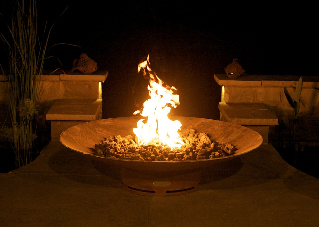 Fire pit with flames burning at night in a garden setting