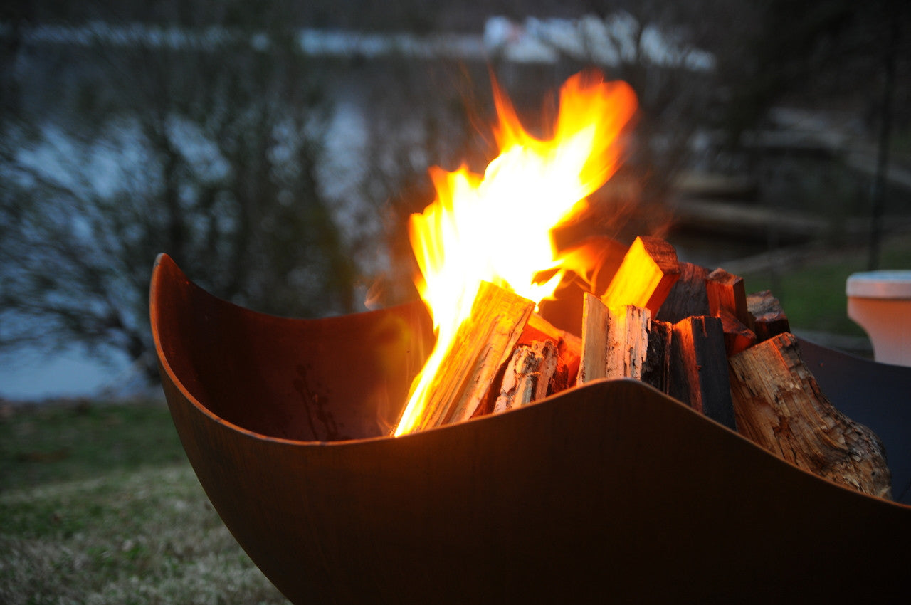 Fire pit with burning wood and flames in an outdoor setting