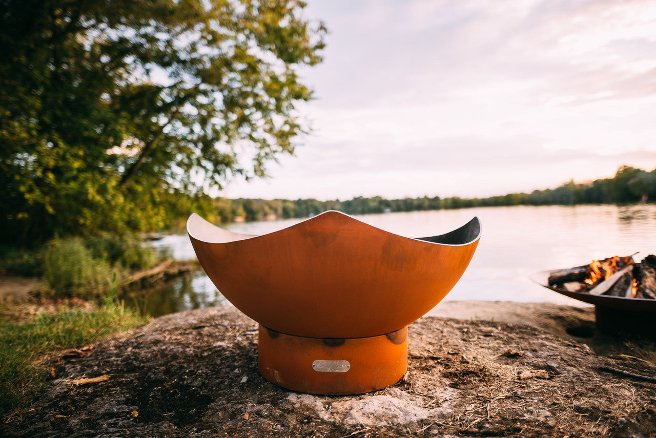 fire pit bowl on a rock by a lake sholwing the magic of Fire Pit Art unique creativity