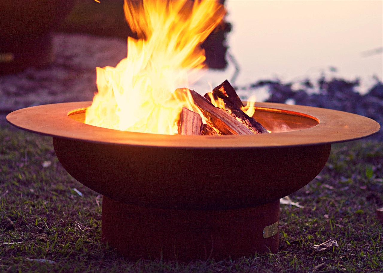 Artist sculpture of fire pit bowl with wood burning flames