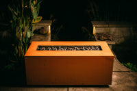 Rectangular fire pit with glowing embers in a dark outdoor setting