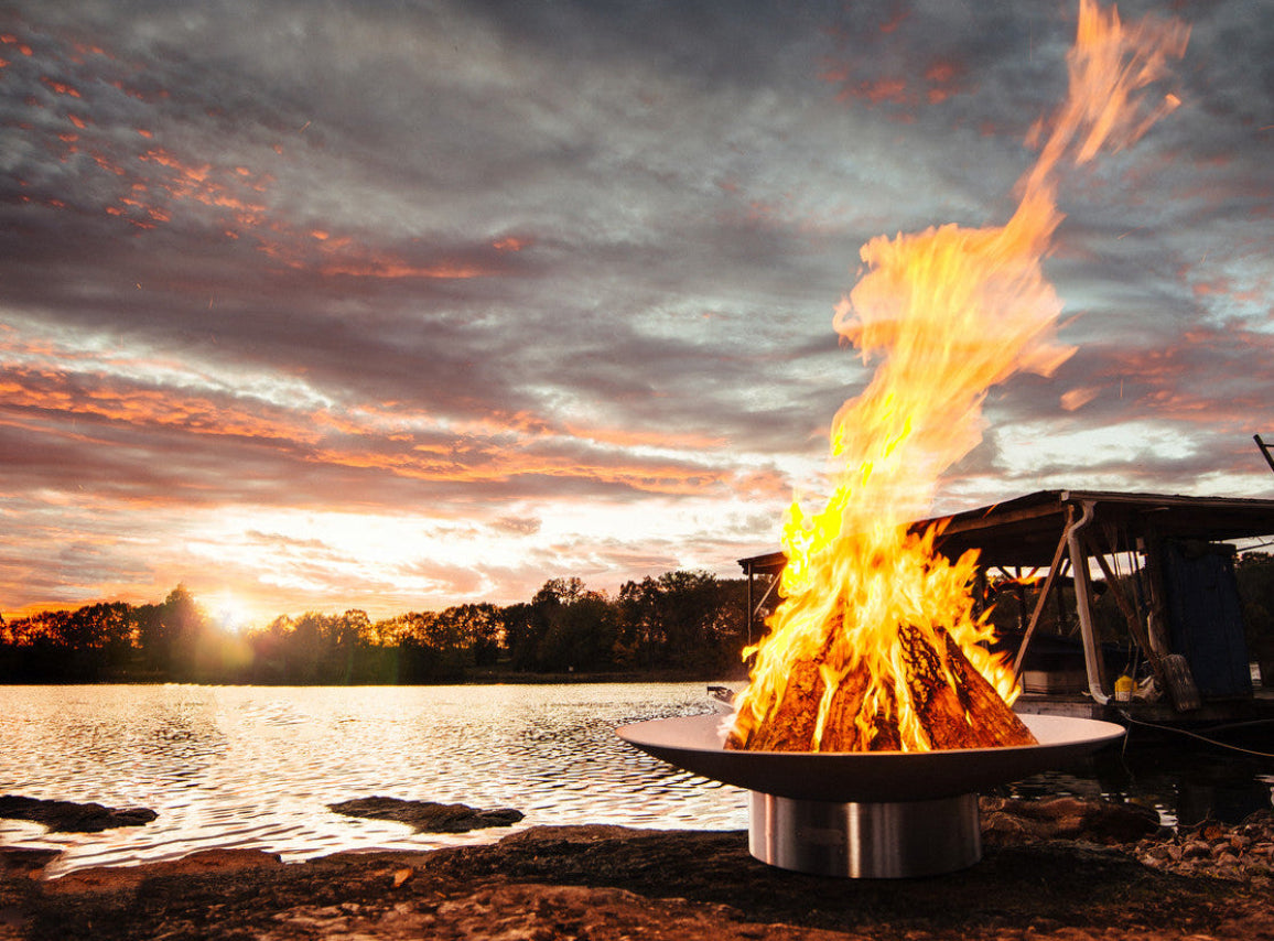 Stainless Steel Fire pit by a lake with a sunset sky